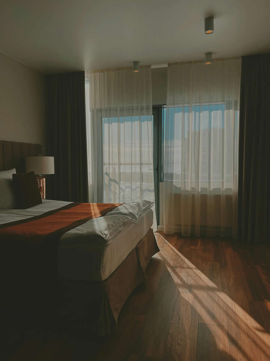 Hotel room with sun peaking into the room