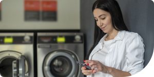 Woman using her phone for digital laundry payments